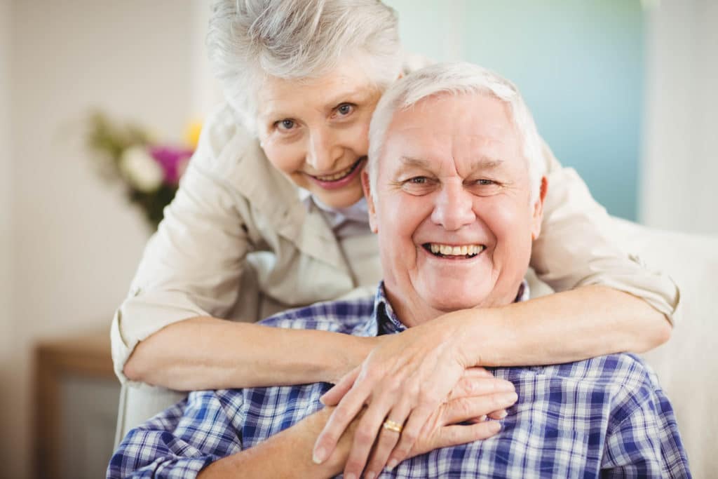Older man and woman embracing in a hug for a picture