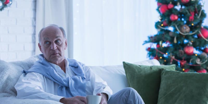 older man sitting on a couch during the holiday season