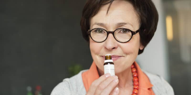 senior woman smelling aromatherapy oil