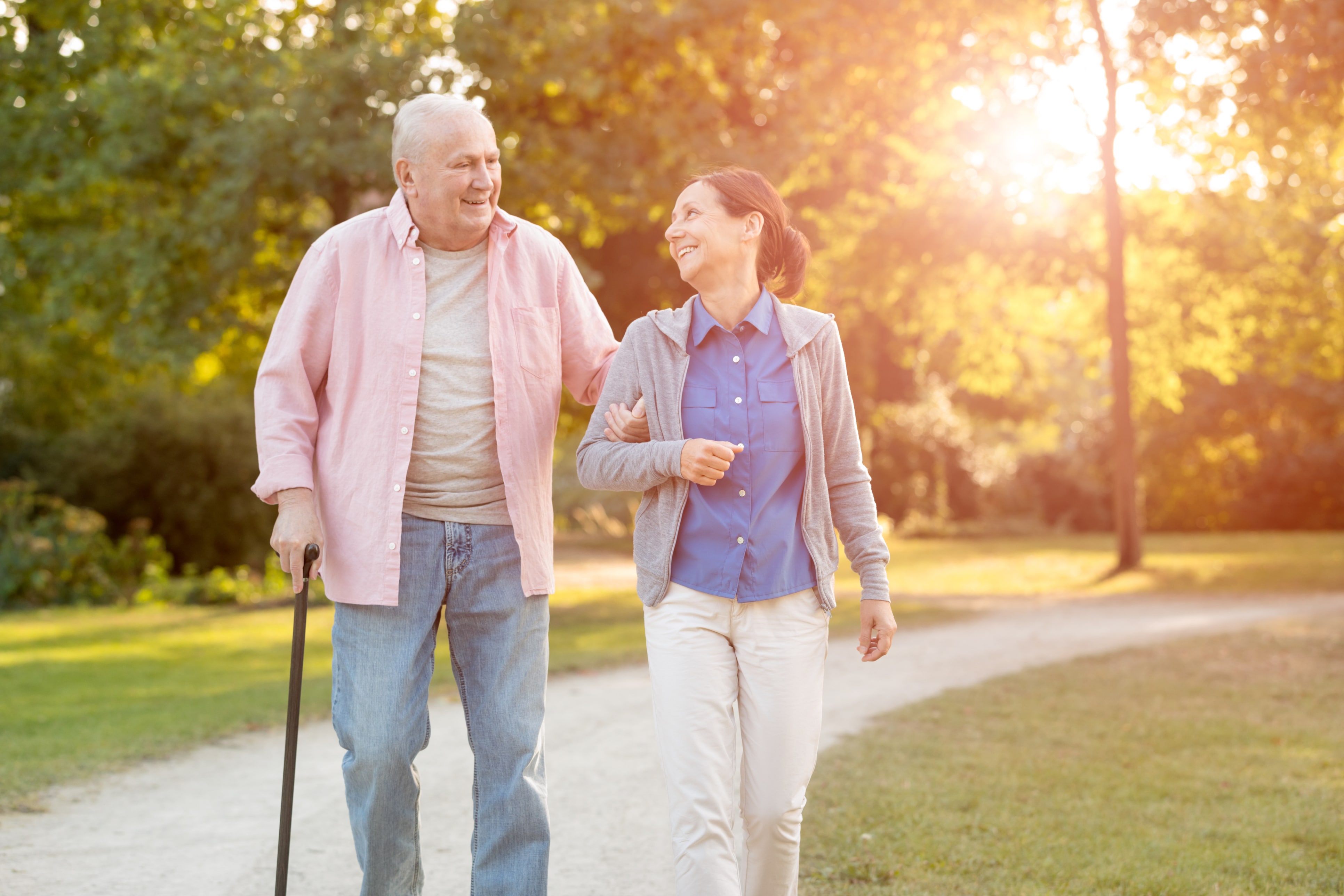 senior woman and caregiver go walking outdoors