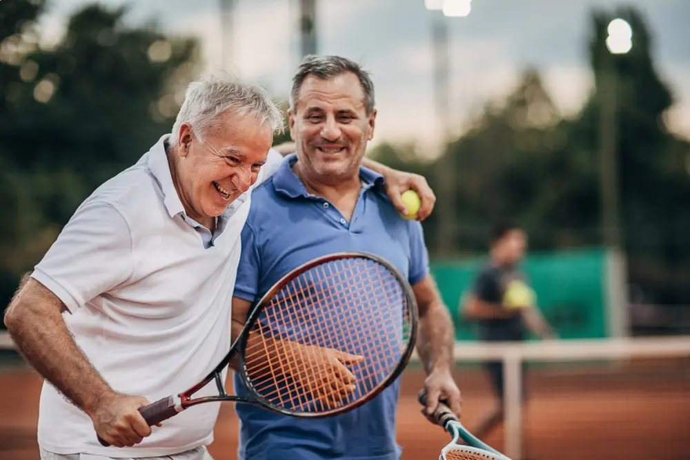 two elder white men playing tennis