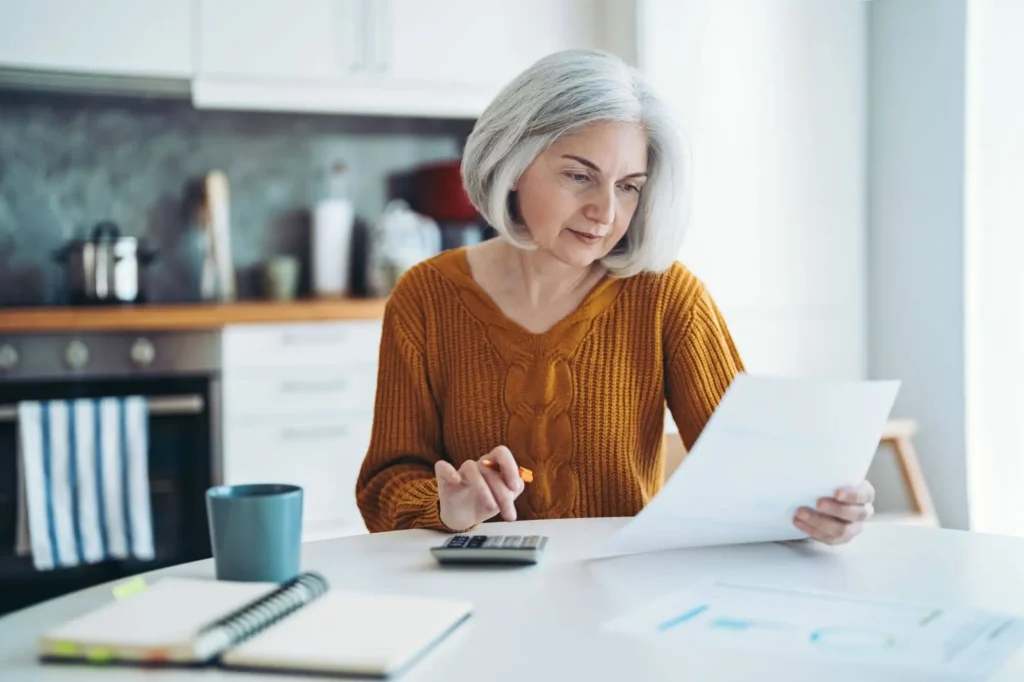 A senior woman looking at the differences between senior living buy-in vs monthly rent as she considers a life plan community like Westminster Village in West Lafayette, IN.